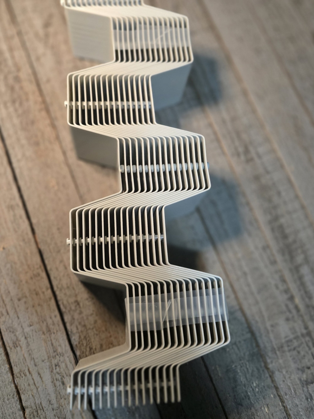 Stack of plastic honeycomb drawer divider panels in a light grey color.